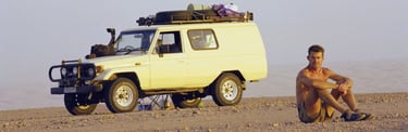 Koos van der Lende on location in Southern Africa, resting beside his 4x4 expedition vehicle during an expedition.