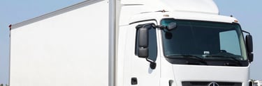 Trucks and equipment transporting materials on a rugged terrain.