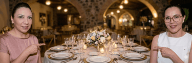 mujeres señalando una mesa de eventos montada