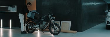 a man standing next to a motorcycle in a garage