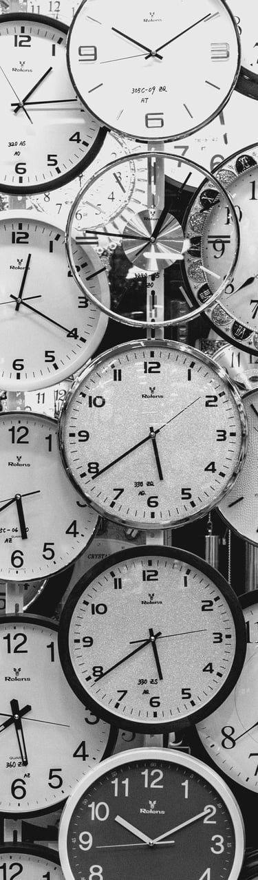 a bunch of clocks on a wall with many different clocks