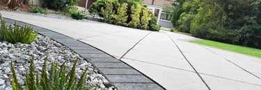 Patio with custom stone circle with aggregates and paving weaving through adventurous garden design