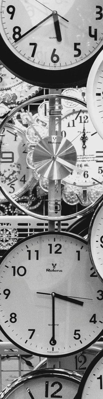 a bunch of clocks on a wall with many different clocks