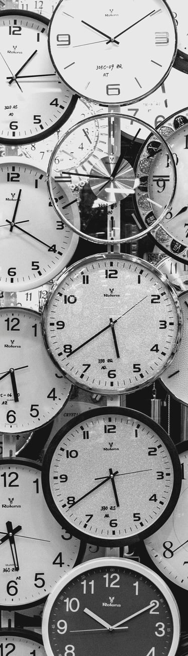 a bunch of clocks on a wall with many different clocks