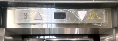 hallway directional indicator above elevator door, with arrows for direction and panel for floor num