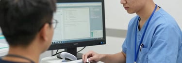 A professional medical equipment technician assisting a hospital staff member with a ventilator setup.