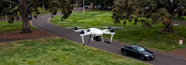 A photographer capturing a vibrant outdoor event with a cinematic drone hovering above.