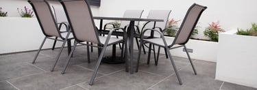  simple, stamped concrete patio with outdoor metal, furniture and white walls