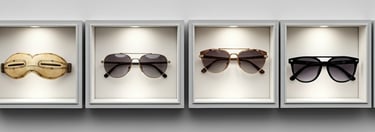 Cuatro pares de lentes de sol exhibidos en vitrinas, mostrando la evolución.