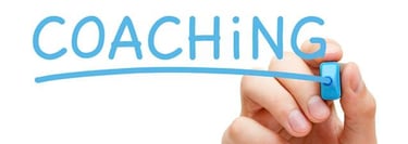 a person writing the word coaching