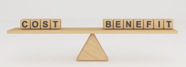 A wooden scale, balancing wooden blocks spelling out the words "cost" and "benefit"