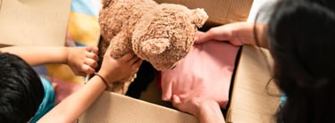 une femme maman et un enfant petit garçon emballe dans un carton un ours en peluche