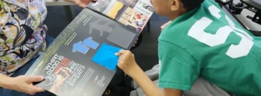 A motorized wheelchair user pointing at a flipbook