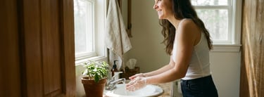 a woman is washing her hands in a sink