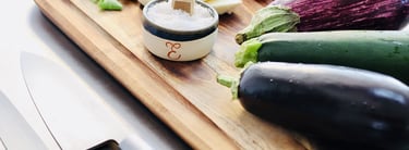 Légumes de saison et petit pot de fleur de sel posés sur une planche à découper