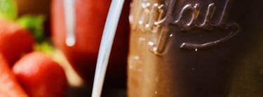 Gros plan sur des conserves en verre de pâte à tartiner et de confitures posées sur une planche