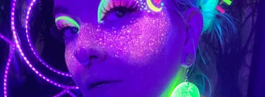 Illuma in blacklight with galaxy makeup which looks like a sky of a million stars across her face