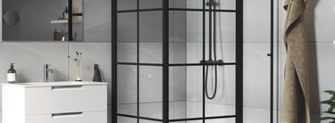 Modern bathroom featuring a black framed glass shower enclosure and a white floating vanity.