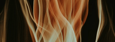 An abstract banner featuring fluid, flowing ribbons of fire in vibrant orange, red, and gold against a dark background.