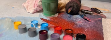 a table with a cup of paint and a cup of paint and tattoo equipment