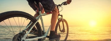 a person riding a bike on a beach