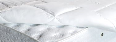 a mattress topper with a pillow and pillows