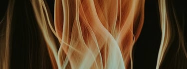 An abstract banner featuring fluid, flowing ribbons of fire in vibrant orange, red, and gold against a dark background.