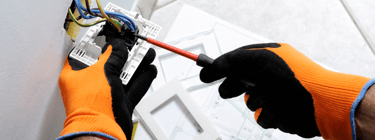 a person in gloves and gloves is holding a tool , Curso Electricidad basica domiciliaria , clases