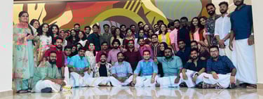 A large group of colleagues posing in traditional Indian attire during a corporate office celebration.