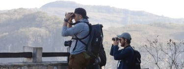 Two birdwatchers at Sumidero Canyon Chiapas look through their binoculars with a mountain backdrop
