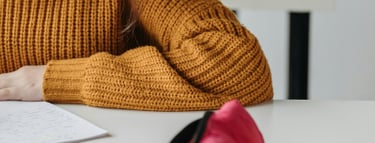 a woman in a yellow sweater is writing