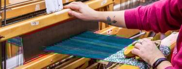 Student using a floor loom in one of our weaving classes.