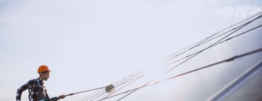 Agent qui nettoie un panneau solaire à la perche