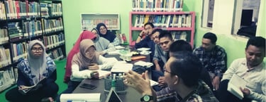 Diskusi strategi program bermutu di ruang, melibatkan relawan, pengelola, dan relawan ahli