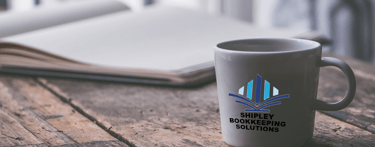 a Shipley Bookkeeping Solutions coffee mug mug with a journal