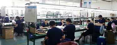 Factory workers in blue uniforms assembling nathroom ware,showers on an industrial production line.