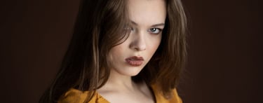 Professionelles Portrait einer jungen Frau mit braunem Haar vor dunklem Hintergrund in Chur