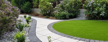 Patio with custom stone circle with aggregates and paving weaving through adventurous garden design