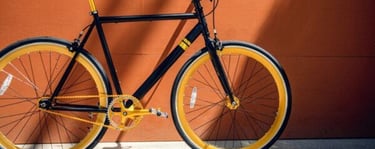 a black bicycle with a yellow rim 