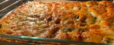 Golden brown cheesy lasagna with bubbling mozzarella baking inside a glass dish in a convection oven.