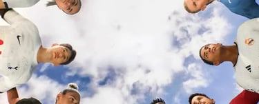 dei calciatori che guardano in basso con il cielo sopra di loro pieno di nuvole