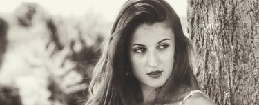 Une jeune belle femme adossée à un arbre