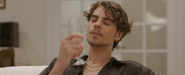 a man with a glass sitting on a couch