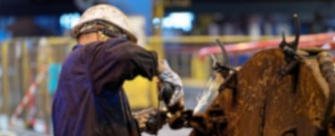 um homem de capacete utilizando uma lixadeira