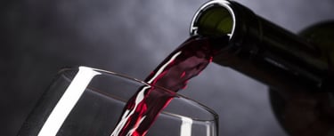 Red wine being poured into a glass against a dark background — Bloupunt Winery, Montagu.
