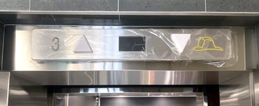 hallway directional indicator above elevator door, with arrows for direction and panel for floor num