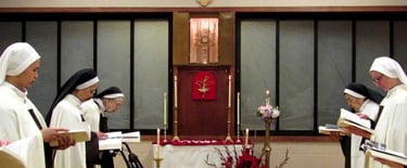 Nuns praying in the choir with the Blessed Sacrament exposed.
