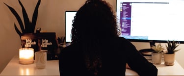 A picture of a girl wearing black and on her black desktop computer