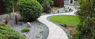 Patio with custom stone circle with aggregates and paving weaving through adventurous garden design