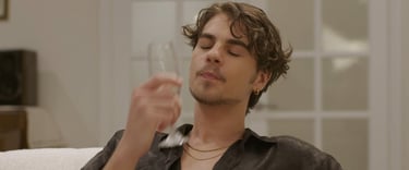 a man with a glass sitting on a couch